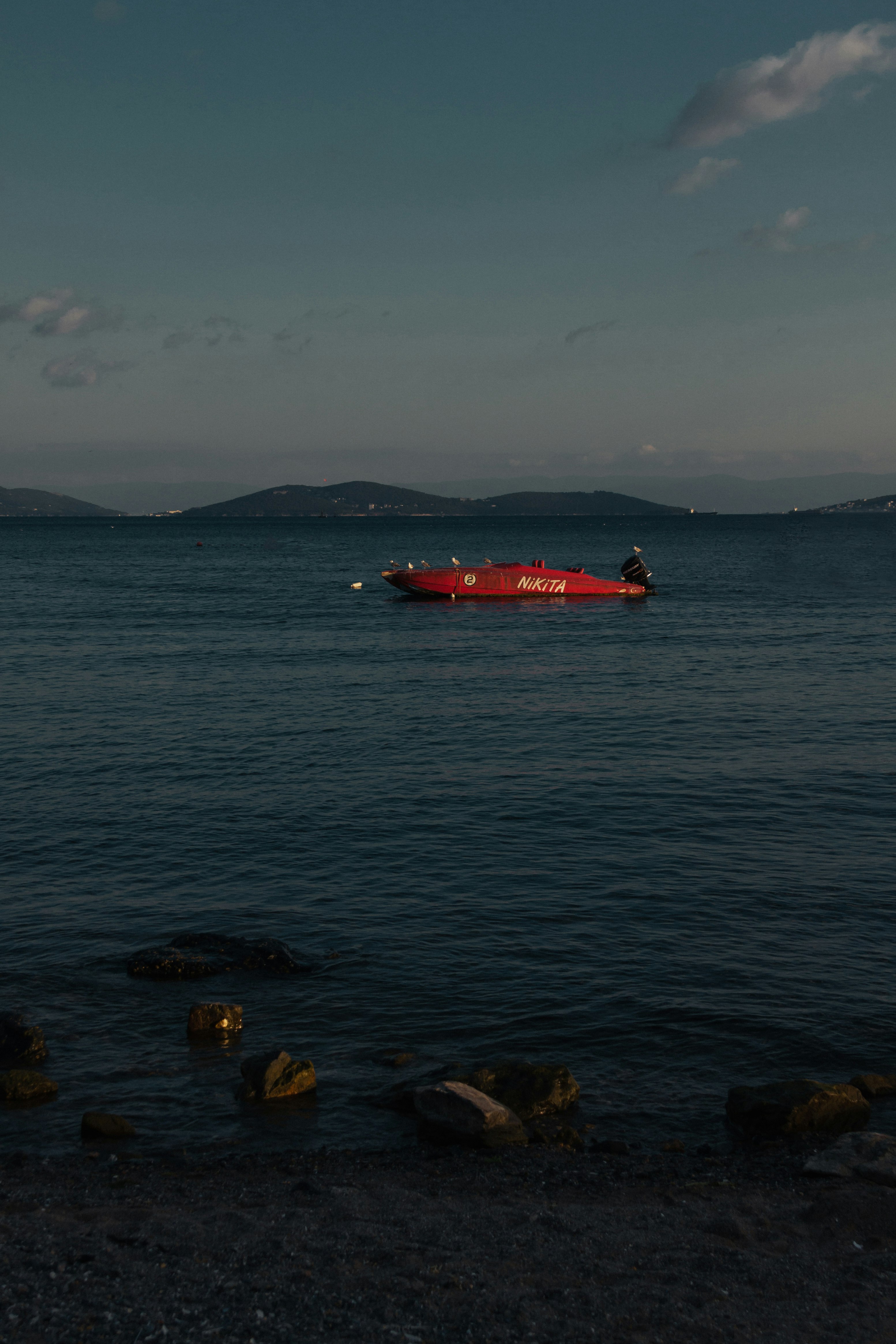 red boat on body of water during daytime